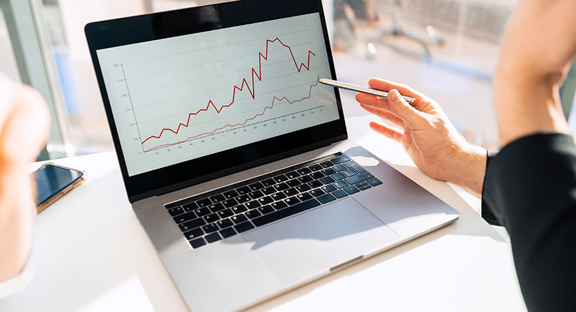 Office workers watching company growth chart on laptop