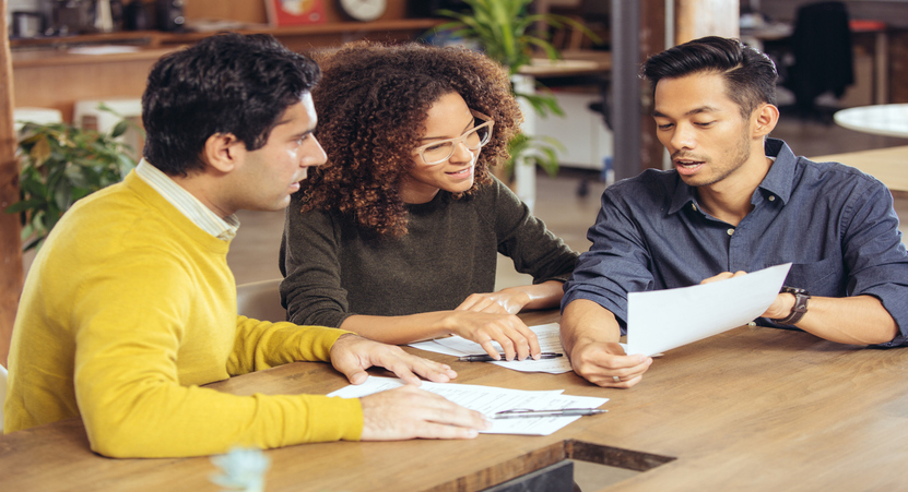 property manager providing a positive resident experience by explaining the terms of a lease to a young couple